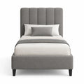 Cama individual de tela gris con cabecero acolchado y patas de madera